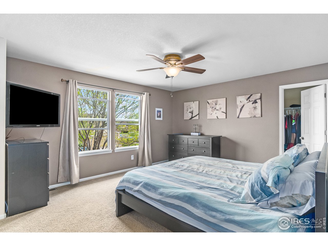 10435 Lower Ridge Road Longmont, CO 80504 - Photo 18 of 26 a bedroom with a large bed and a flat screen tv