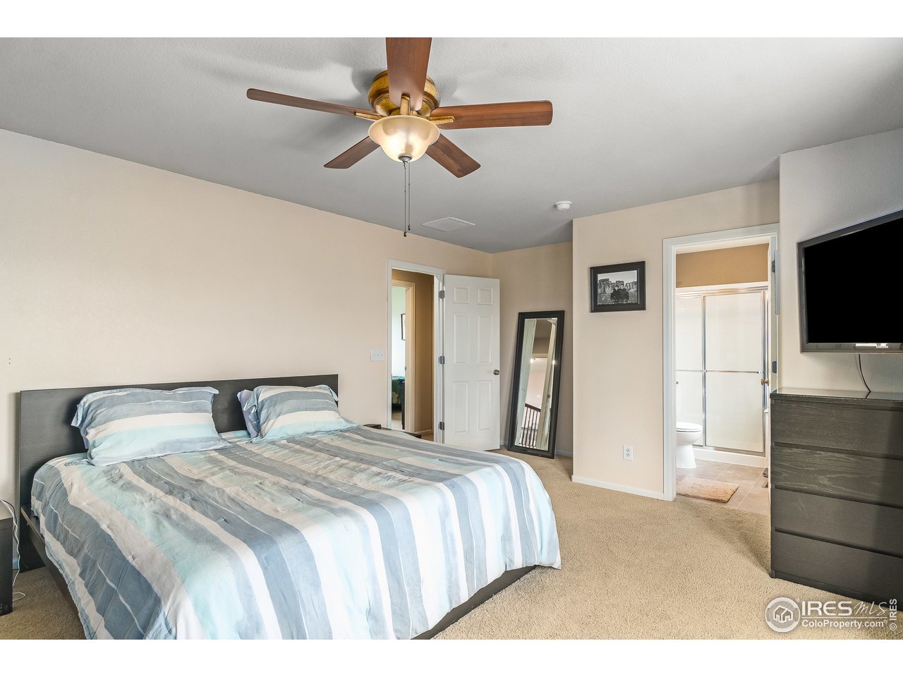 10435 Lower Ridge Road Longmont, CO 80504 - Photo 19 of 26 a bedroom with a large bed and a flat screen tv