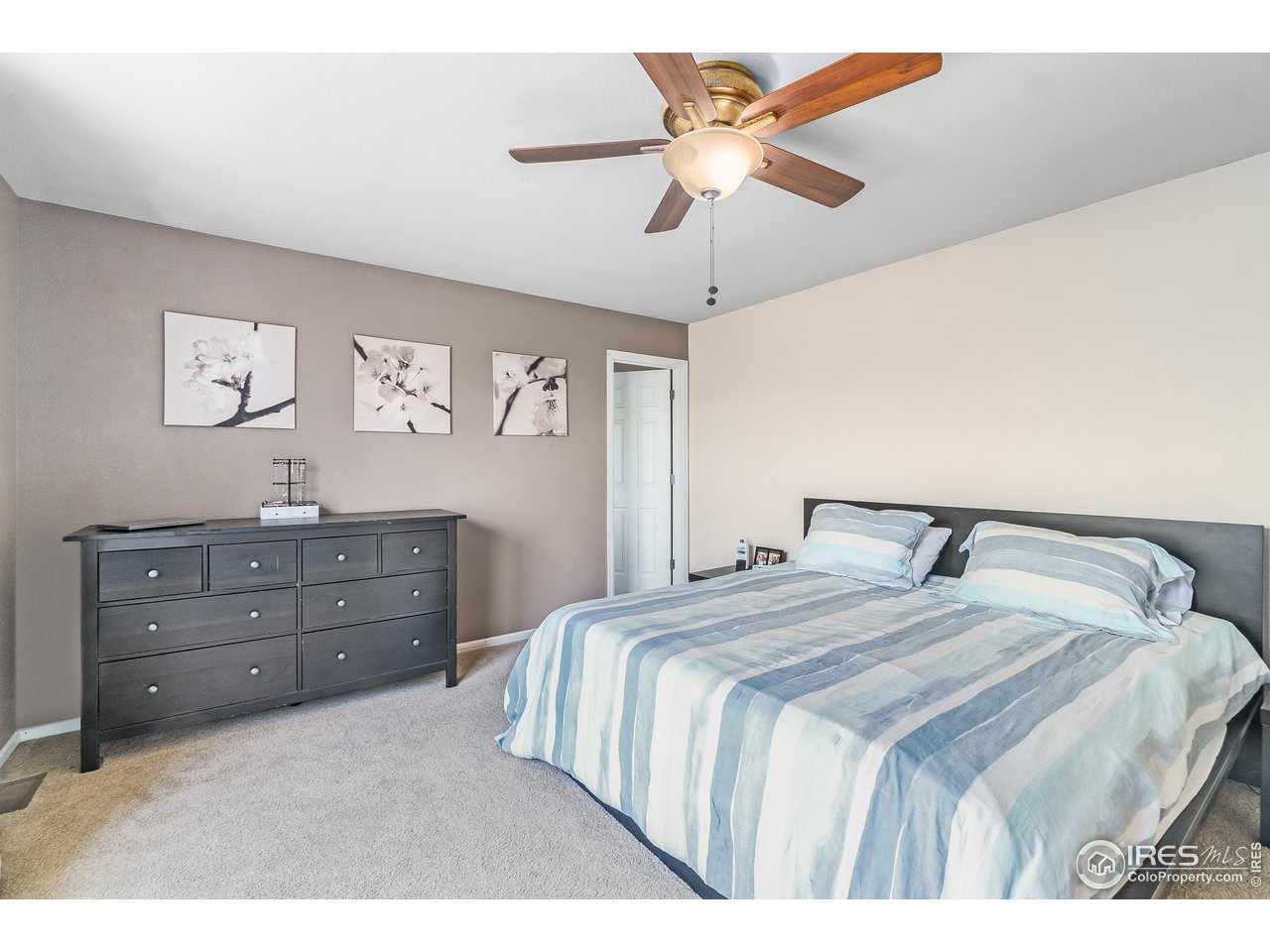 10435 Lower Ridge Road Longmont, CO 80504 - Photo 20 of 26 a bedroom with a bed and a chandelier