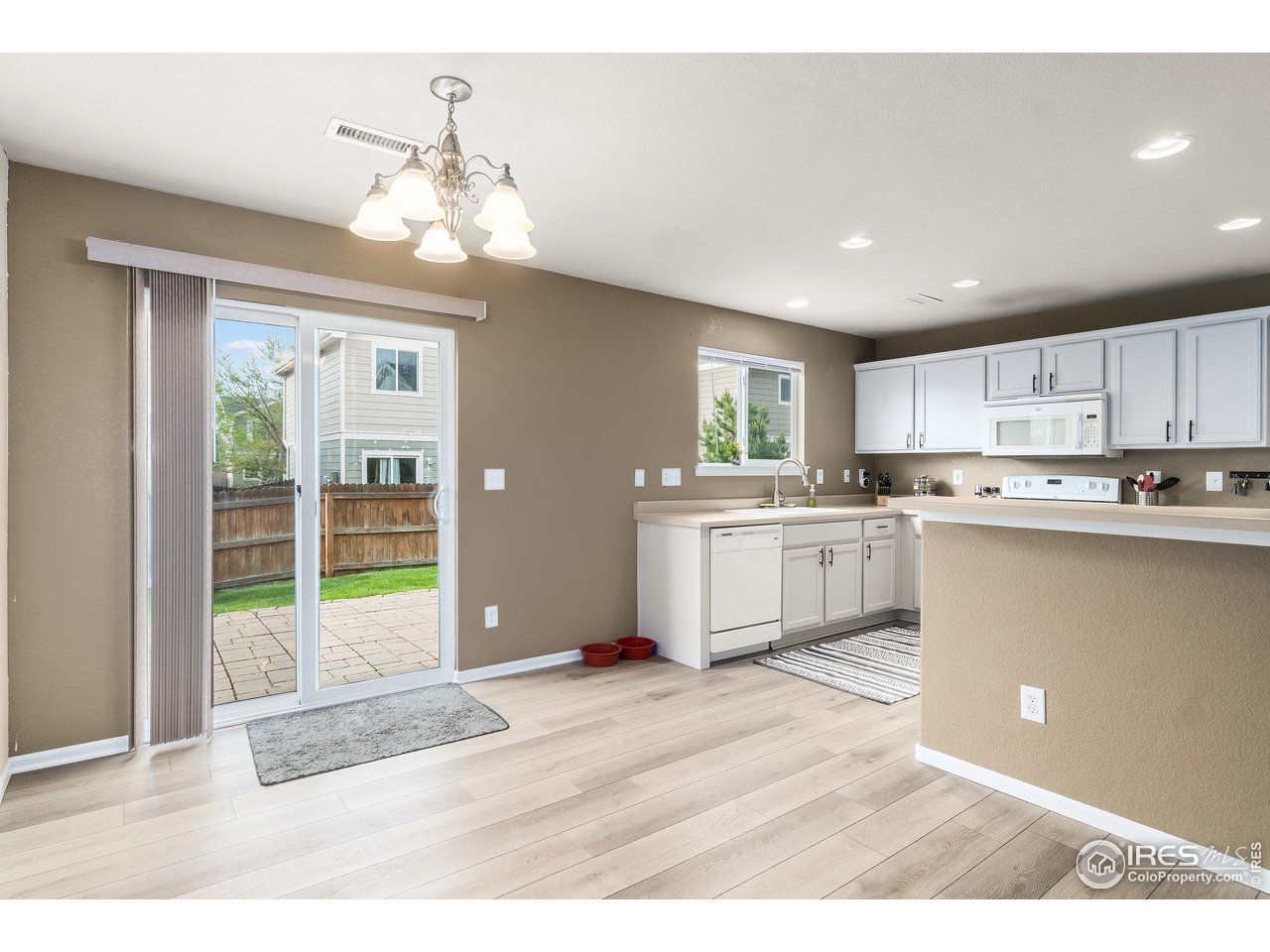 10435 Lower Ridge Road Longmont, CO 80504 - Photo 6 of 26 a kitchen with stainless steel appliances granite countertop a sink dishwasher a refrigerator and a stove with wooden floor