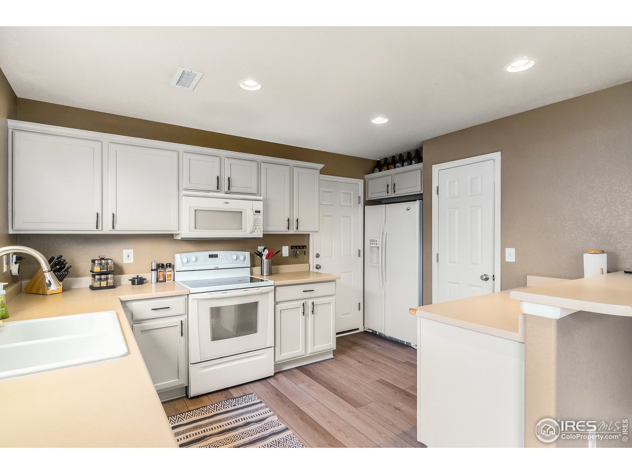 10435 Lower Ridge Road Longmont, CO 80504 - Photo 9 of 26 a kitchen with a sink a stove a refrigerator and cabinets