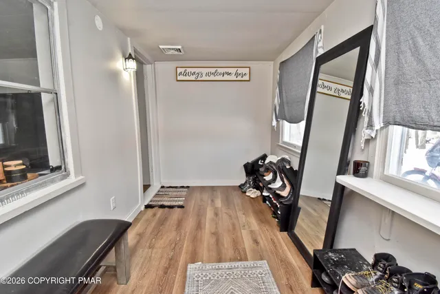 a view of a hallway with wooden floor and windows