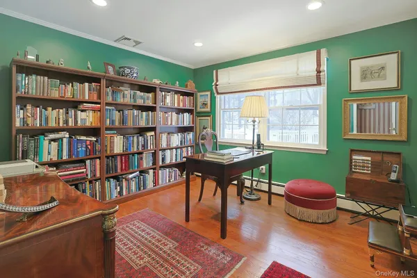 a living room with furniture a bookshelf and a window