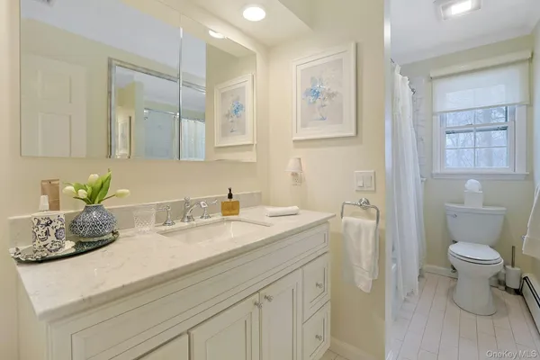 a bathroom with a granite countertop sink a toilet and a mirror