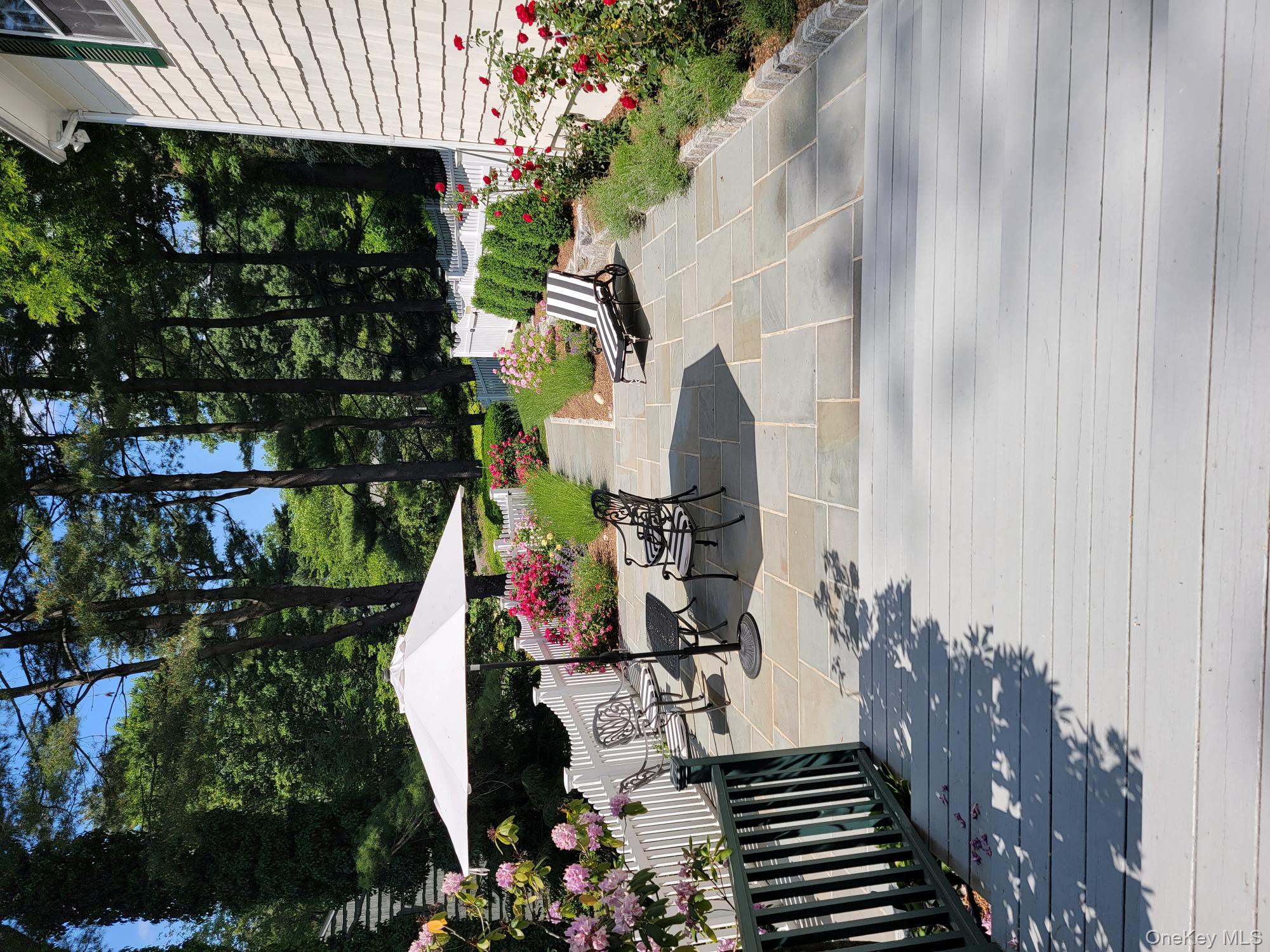 103 River Road Briarcliff Manor, NY 10510 - Photo 26 of 37 a view of a patio with a table and chairs under an umbrella