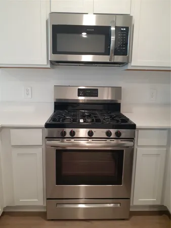a stove top oven sitting inside of a kitchen