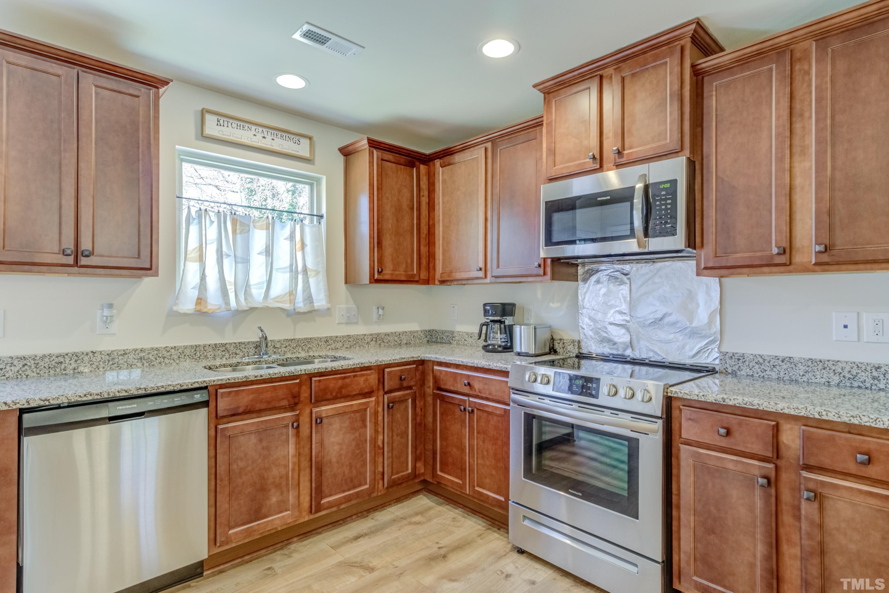 240 Spark Street Raleigh, NC 27606 - Photo 15 of 35 a kitchen with granite countertop cabinets stainless steel appliances a sink and window