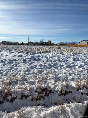a view of a dry yard with wooden fence
