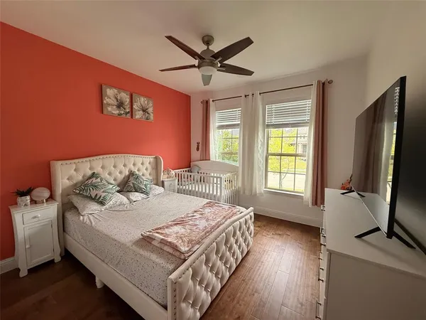 a bedroom with a bed television and a window