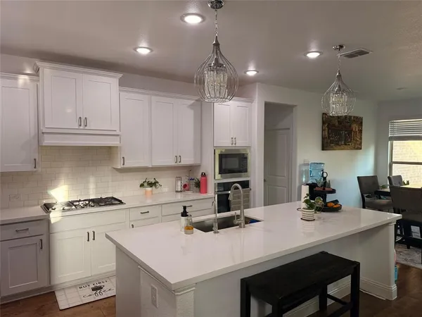 a kitchen with a sink a stove a refrigerator and cabinets