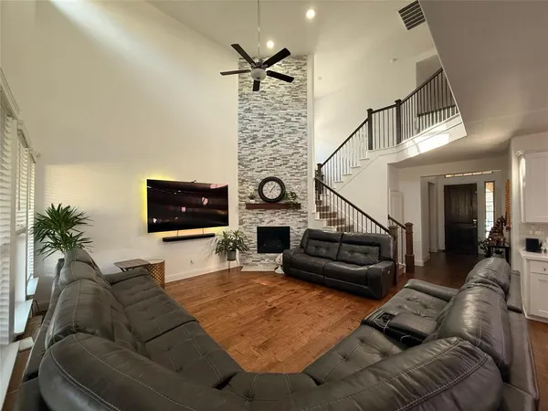 a open kitchen with a sink a stove a refrigerator cabinets and a dining table with wooden floor