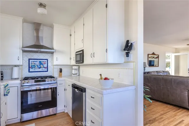 a kitchen with stainless steel appliances a stove a sink and a refrigerator