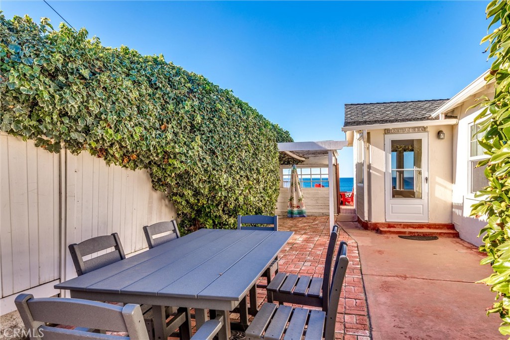 2850 Studio Drive Cayucos, CA 93430 - Photo 24 of 54 a view of a patio with table and chairs with wooden floor and plants