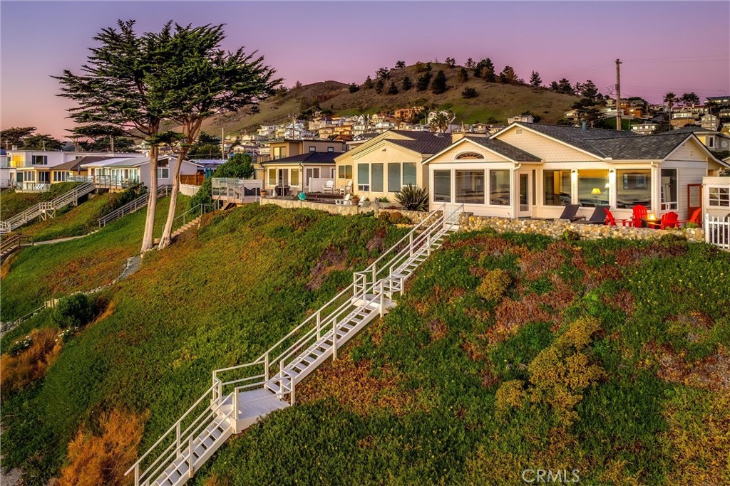 2850 Studio Drive Cayucos, CA 93430 - Photo 6 of 54 a view of a white house with a yard and potted plants
