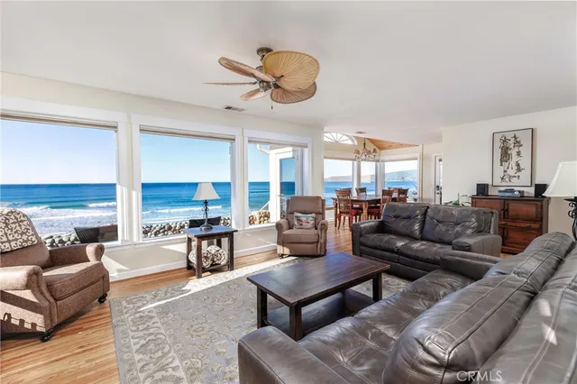 a living room with furniture kitchen view and a large window