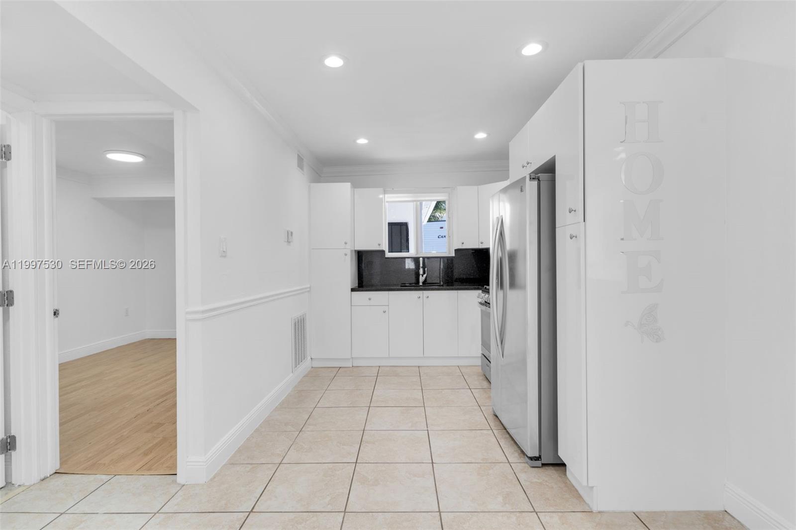201 Southwest 51st Court, Unit 2 Miami, FL 33134 - Photo 3 of 10 a large white kitchen with a refrigerator and a stove top oven