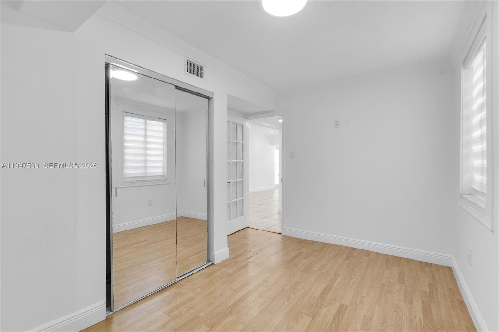 201 Southwest 51st Court, Unit 2 Miami, FL 33134 - Photo 6 of 10 an empty room with wooden floor and windows