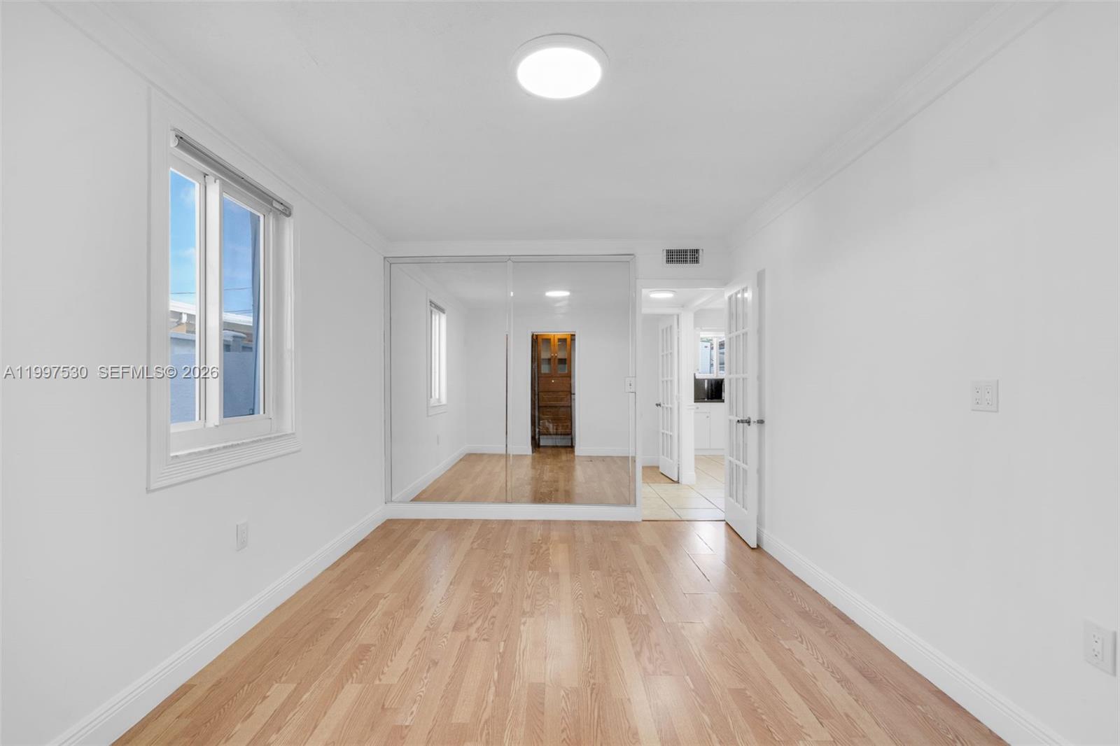 201 Southwest 51st Court, Unit 2 Miami, FL 33134 - Photo 8 of 10 a view of an empty room with wooden floor and a window