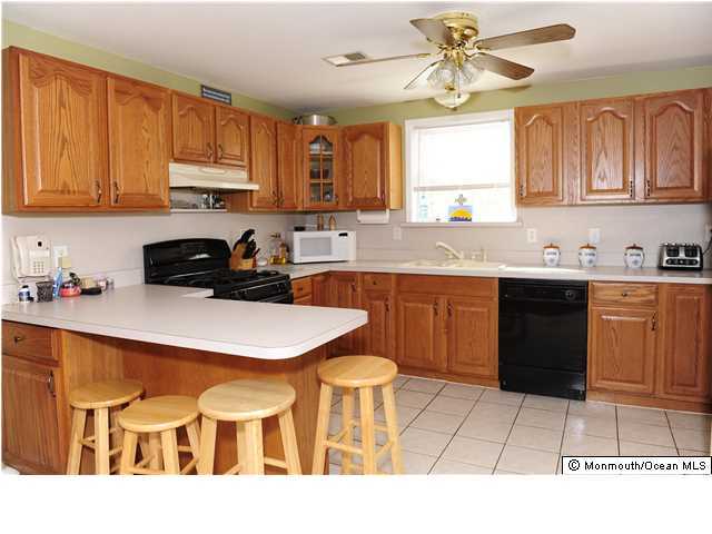 114 Bergerville Road Freehold, NJ 07728 - Photo 6 of 18 a kitchen with a sink a stove a refrigerator and cabinets