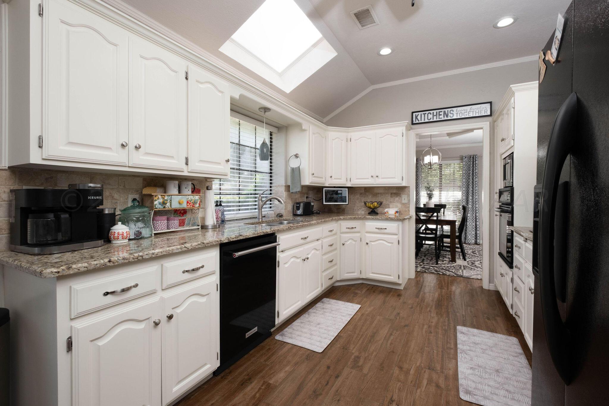 4400 Baltus Place Amarillo, TX 79121 - Photo 12 of 39 a kitchen with granite countertop white cabinets and white appliances