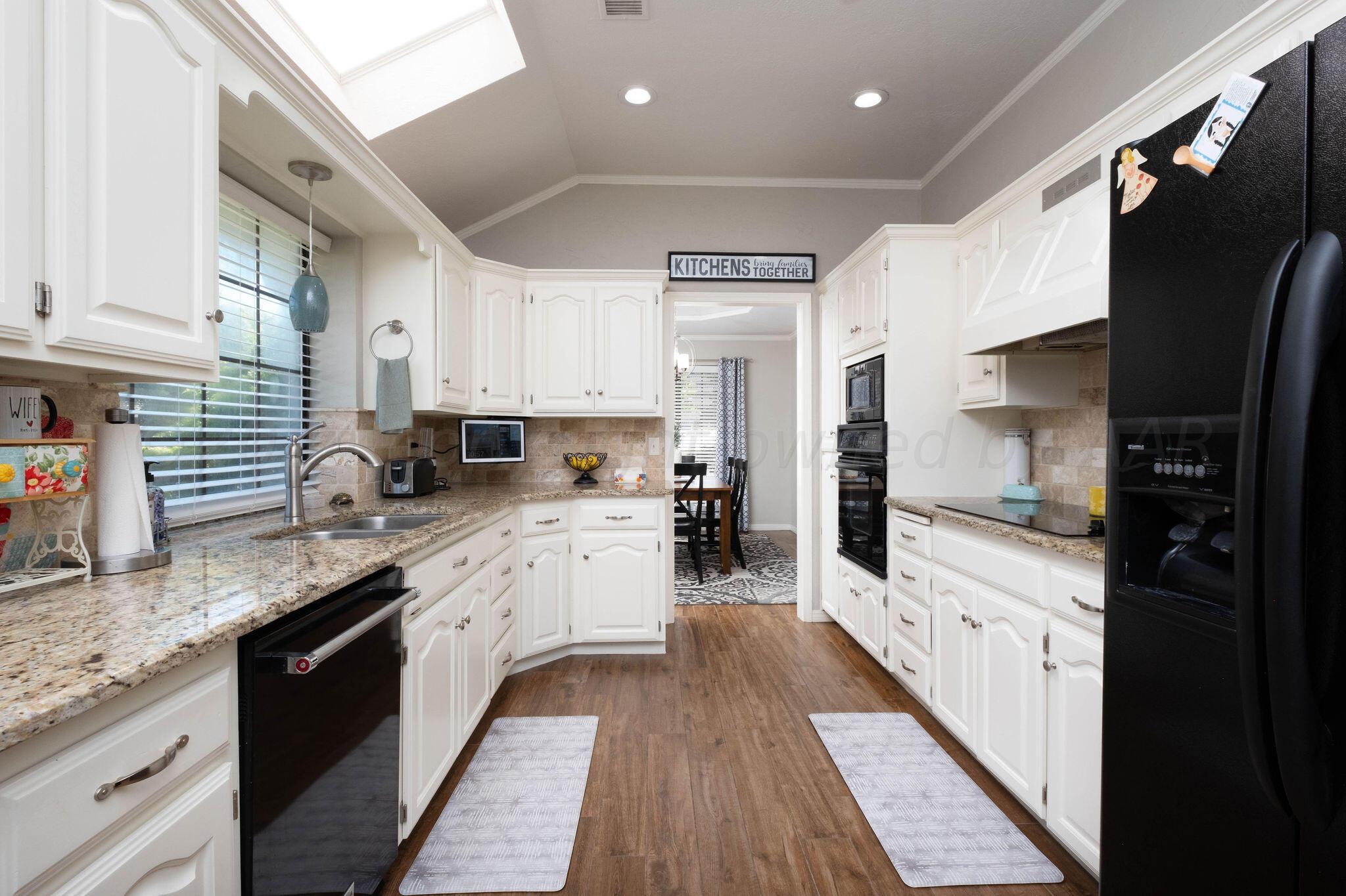 4400 Baltus Place Amarillo, TX 79121 - Photo 13 of 39 a kitchen with stainless steel appliances granite countertop a refrigerator a sink dishwasher a stove and white countertops with wooden floor