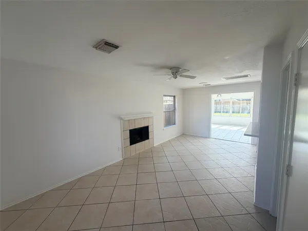 a view of an empty room with a fireplace and a window