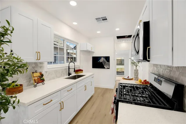 a kitchen with stainless steel appliances a sink stove and cabinets
