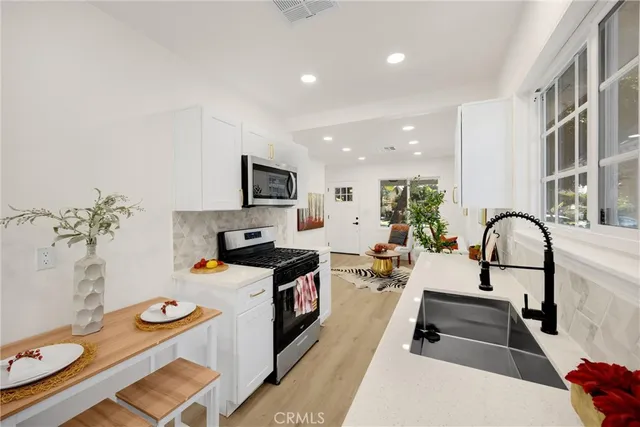 a kitchen with stainless steel appliances a stove a sink and a refrigerator