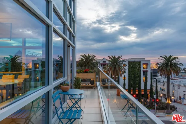 a view of a balcony with furniture and a potted plant