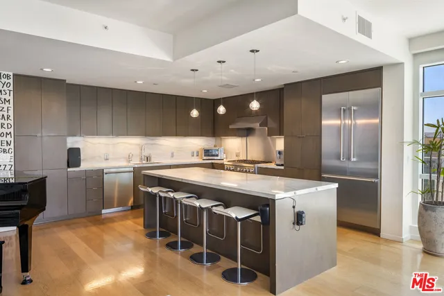 a kitchen with stainless steel appliances granite countertop a sink a stove and a refrigerator