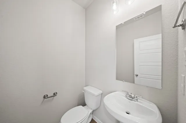 a bathroom with a sink mirror and toilet