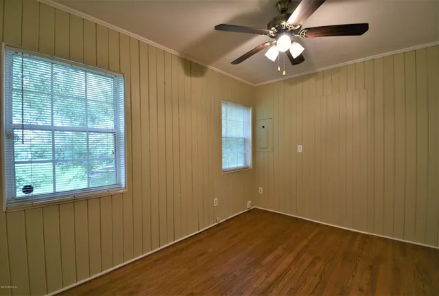 an empty room with a window and a fan