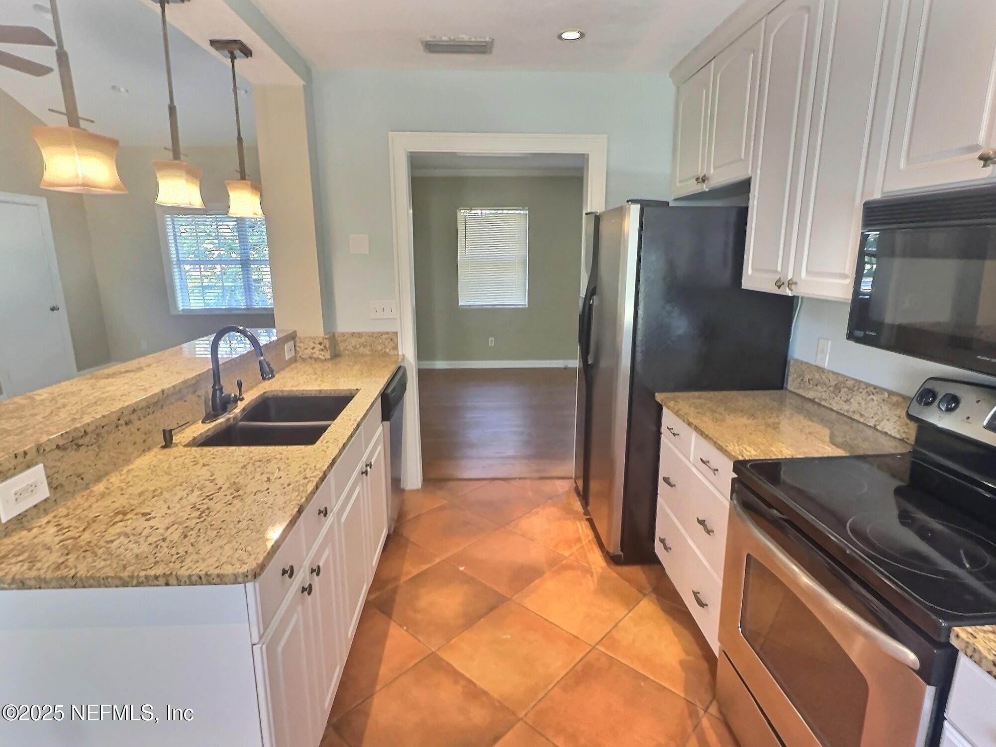 4253 Roma Boulevard Jacksonville, FL 32210 - Photo 4 of 17 a kitchen with kitchen island granite countertop a sink stove and refrigerator