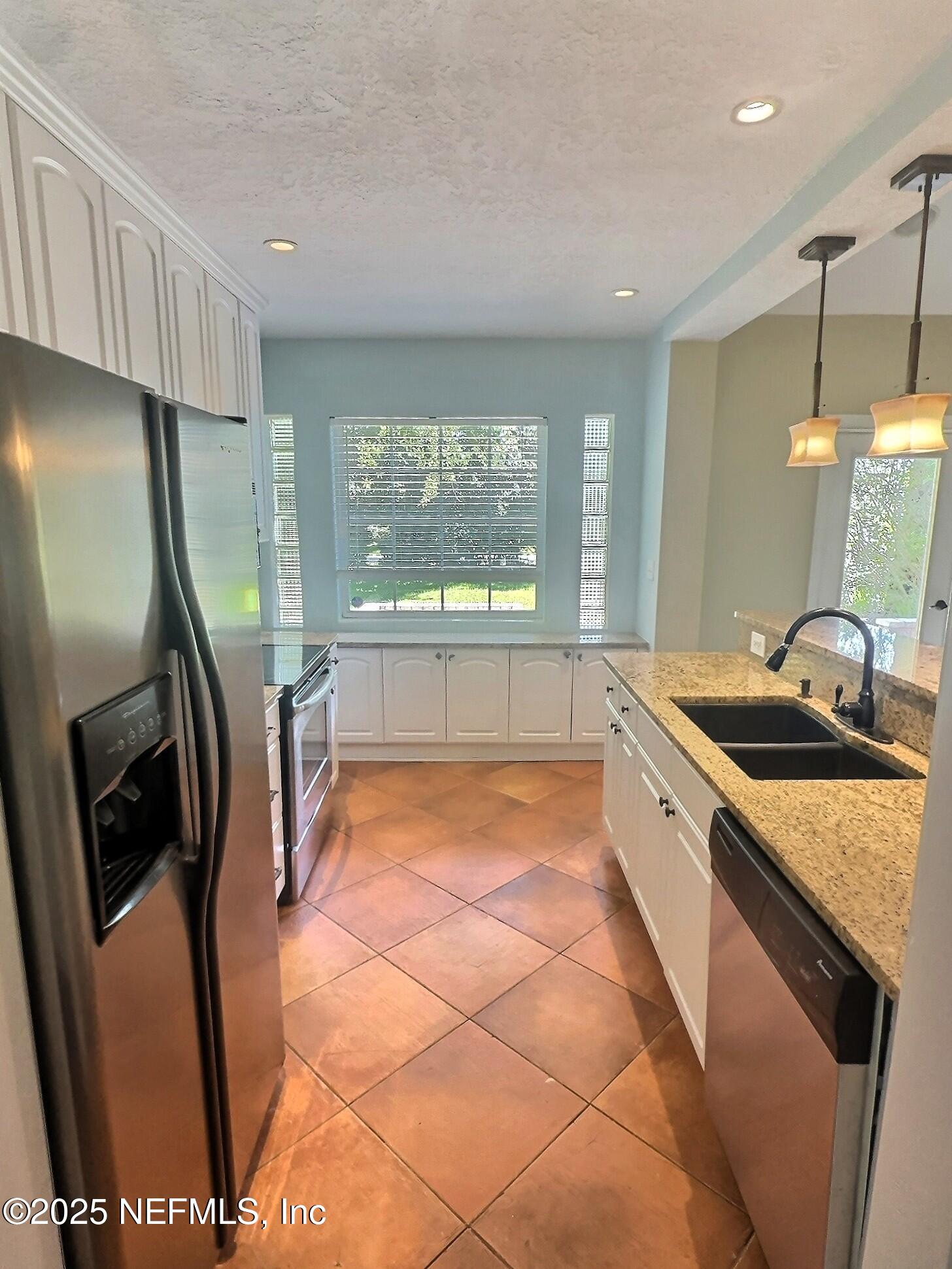 4253 Roma Boulevard Jacksonville, FL 32210 - Photo 5 of 17 a kitchen with stainless steel appliances granite countertop a sink a stove a refrigerator a washer dryer and a washer