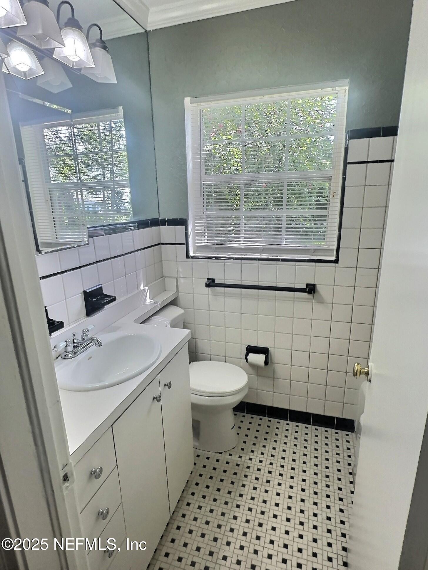 4253 Roma Boulevard Jacksonville, FL 32210 - Photo 10 of 17 a bathroom with a sink a toilet a window and vanity