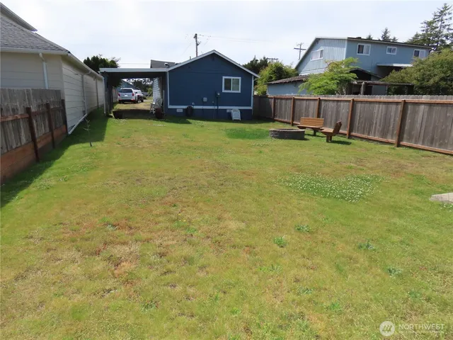 a view of a yard with wooden fence