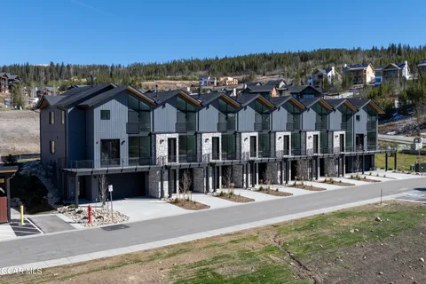a view of a big house with a big yard and large trees