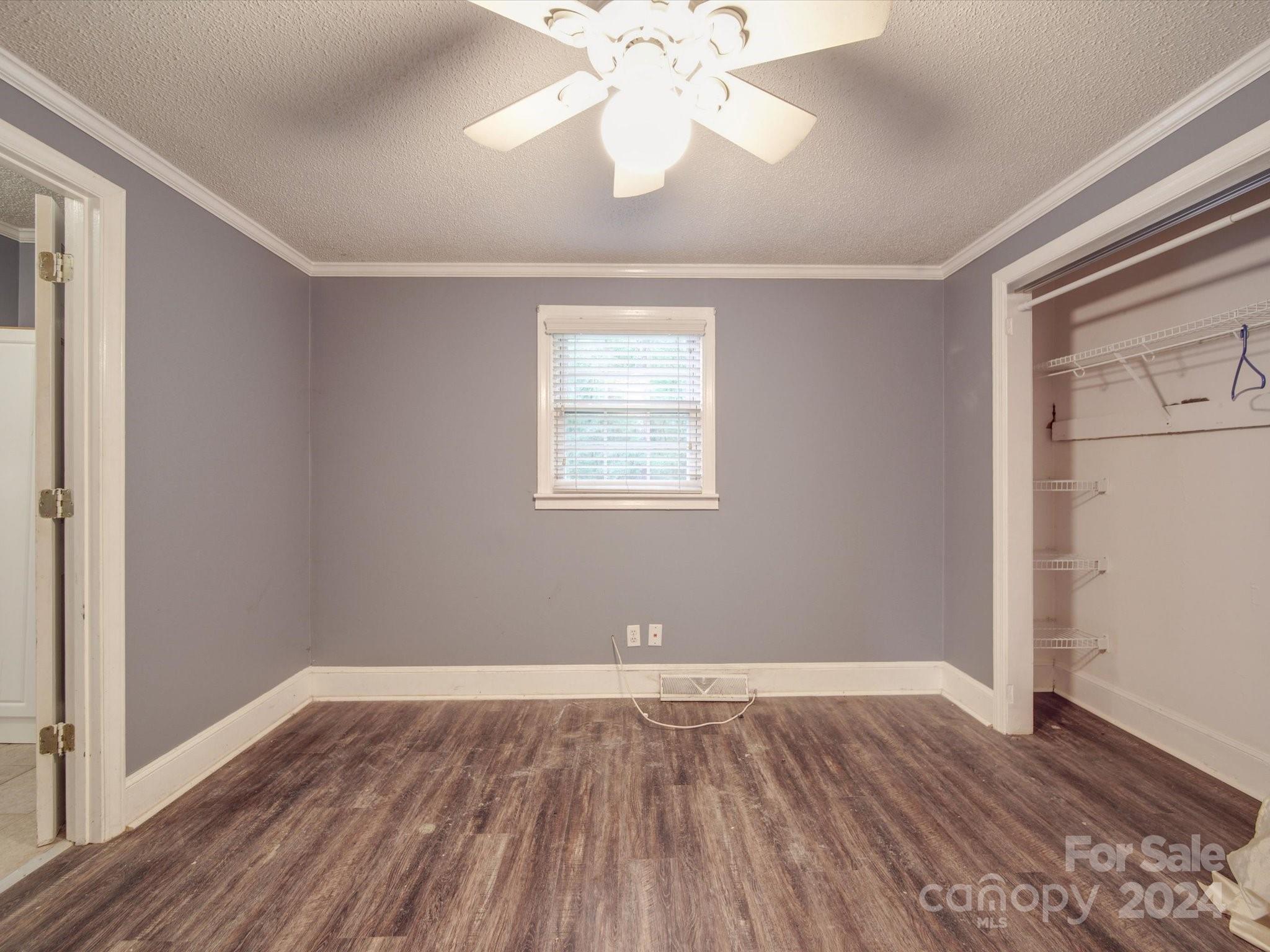 20082 Coley Store Road Locust, NC 28097 - Photo 20 of 43 an empty room with wooden floor chandelier fan and windows