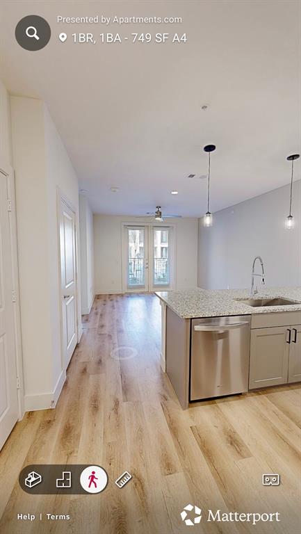 7201 Stacy Road McKinney, TX 75070 - Photo 6 of 6 Kitchen with open floor plan, light stone counters, light wood-style flooring, stainless steel dishwasher, and hanging light fixtures