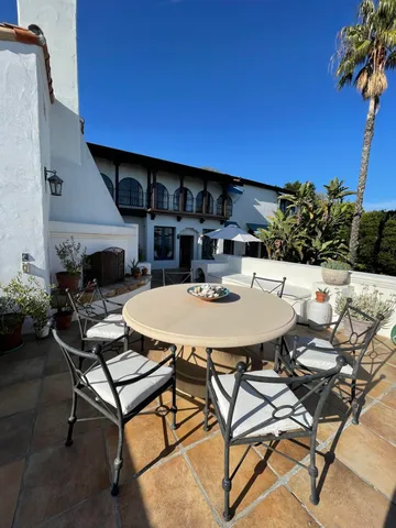 a view of patio with chairs and table under an umbrella