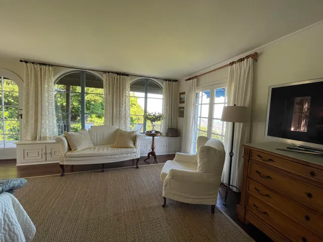a living room with furniture a flat screen tv and a window
