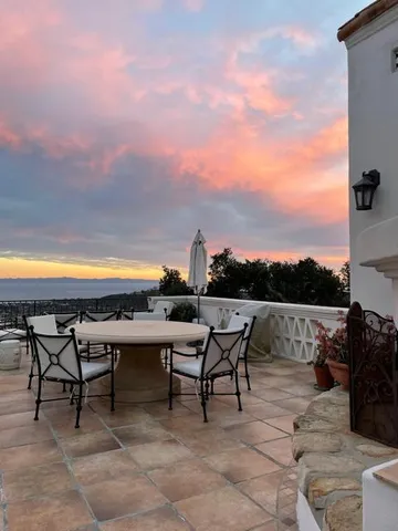 a view of a terrace with furniture and a garden