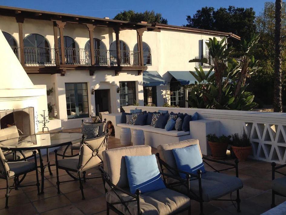 0 Mission Ridge Road Santa Barbara, CA 93103 - Photo 8 of 71 a view of a patio with couches table and chairs under an umbrella with a fireplace