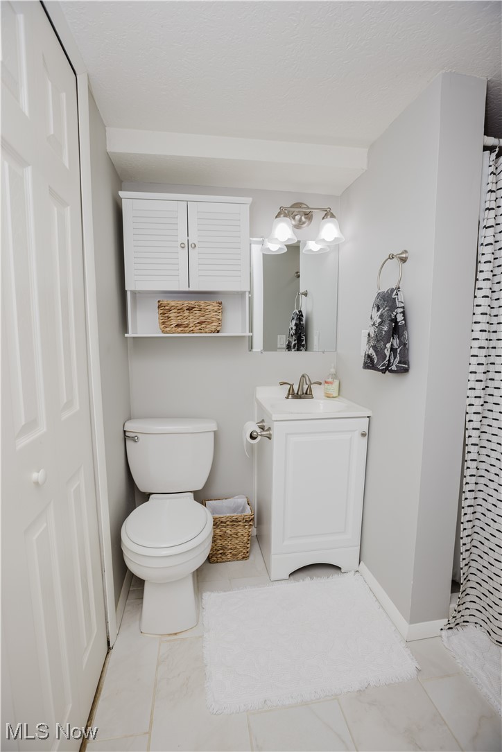 16940 Howe Road Strongsville, OH 44136 - Photo 14 of 33 Bathroom with vanity, a shower with curtain, light tile patterned flooring, and a textured ceiling