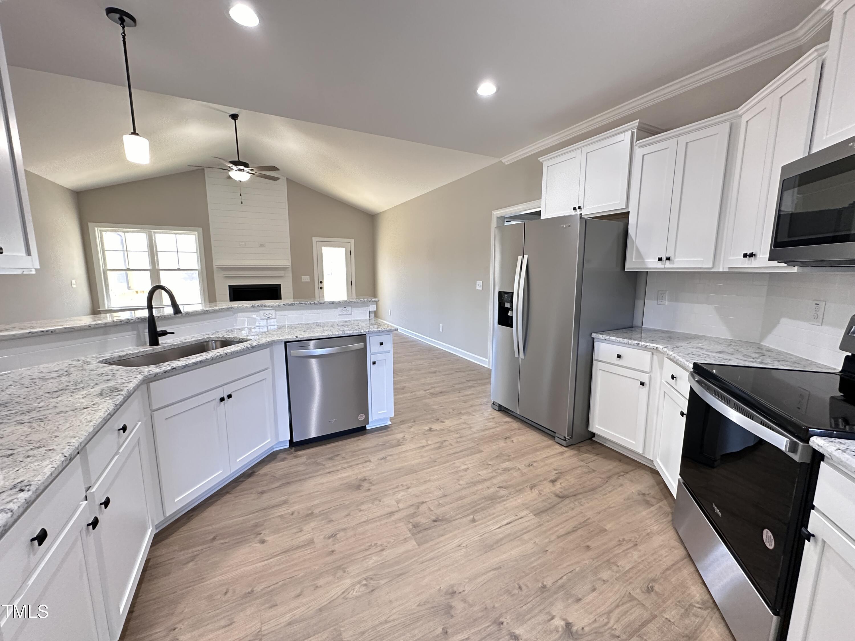 180 Pepperdam Street Smithfield, NC 27577 - Photo 3 of 8 a large white kitchen with a stove a sink dishwasher a refrigerator and a oven with wooden floor