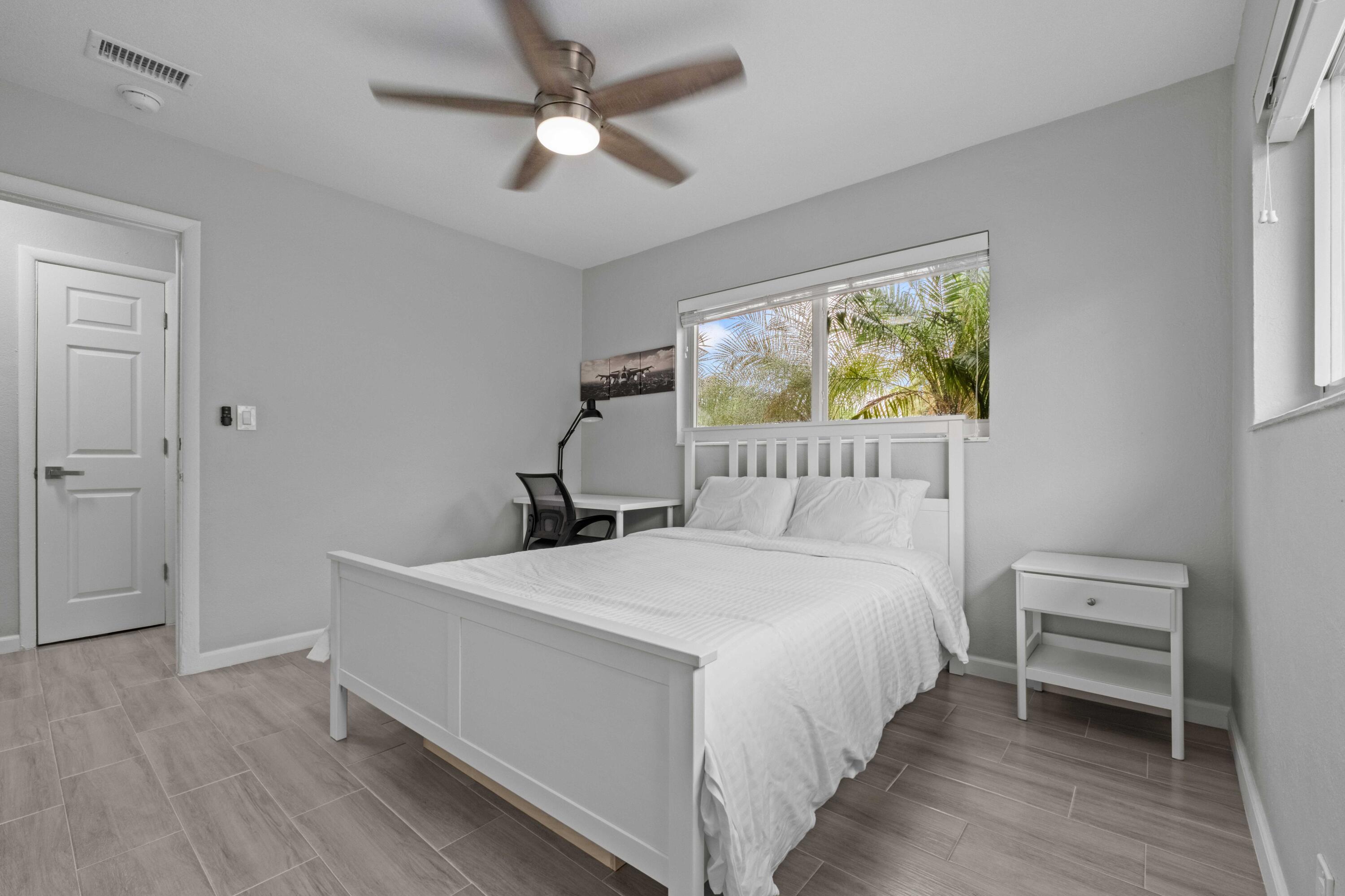 1007 Northeast 9th Court Pompano Beach, FL 33060 - Photo 14 of 21 a bedroom with a bed a window and a chandelier