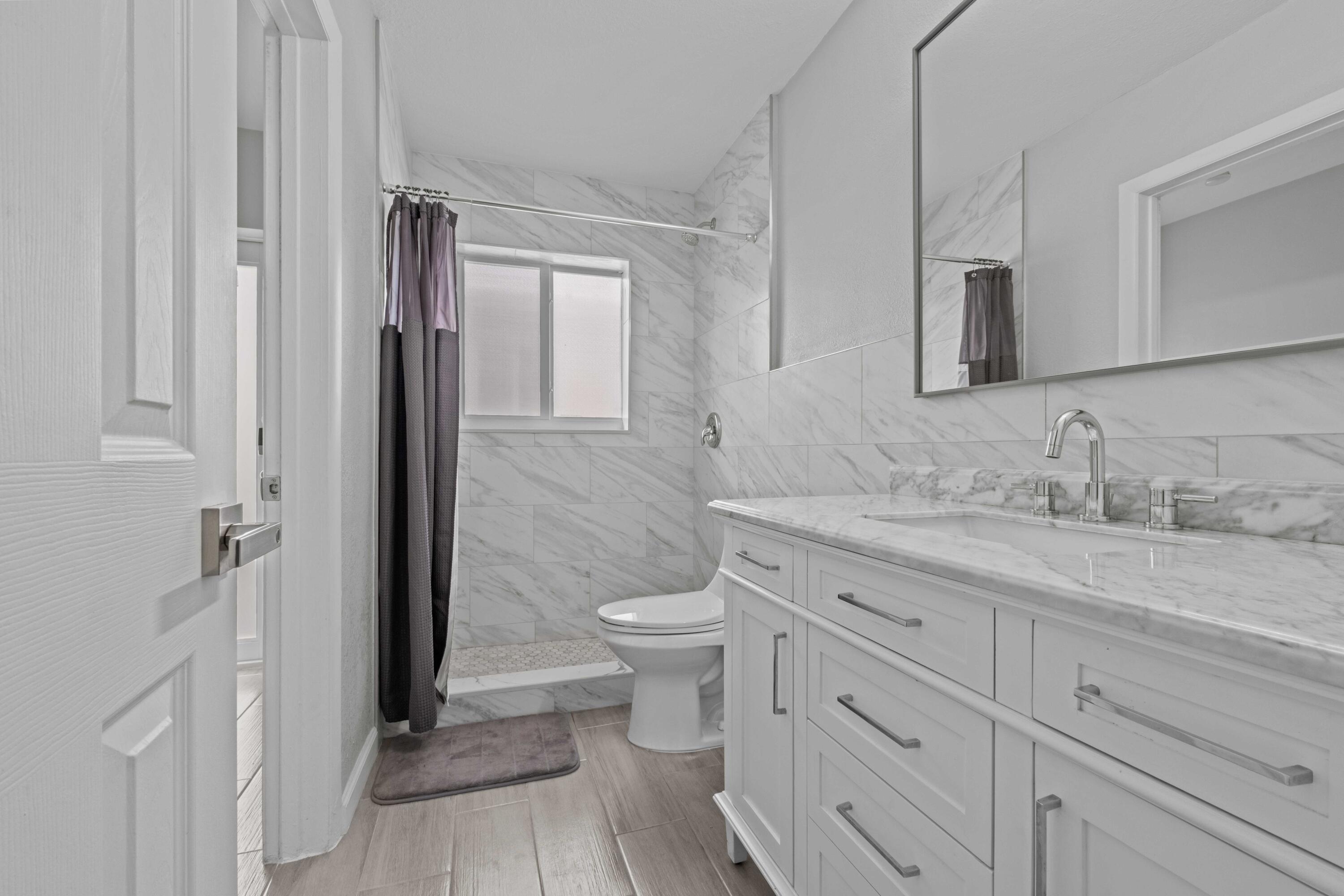 1007 Northeast 9th Court Pompano Beach, FL 33060 - Photo 10 of 21 a bathroom with a granite countertop toilet sink and mirror