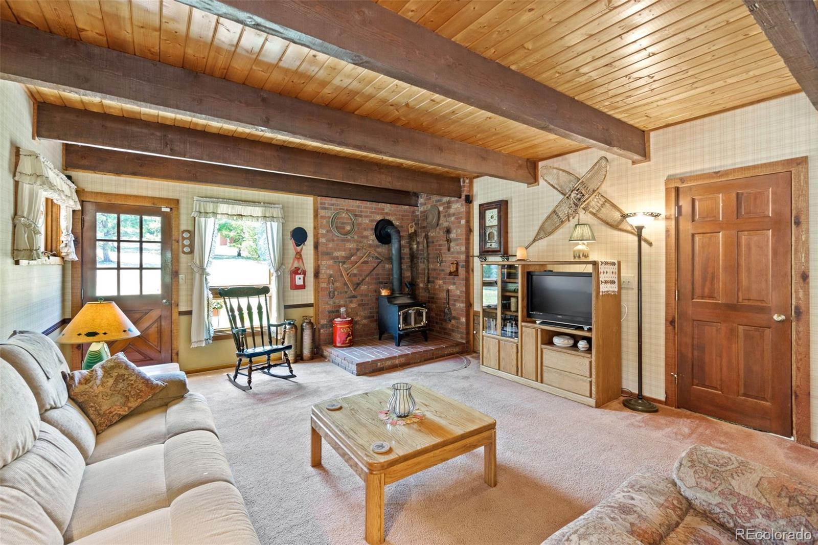 600 Old Squaw Pass Road Evergreen, CO 80439 - Photo 16 of 40 a living room with furniture and a flat screen tv