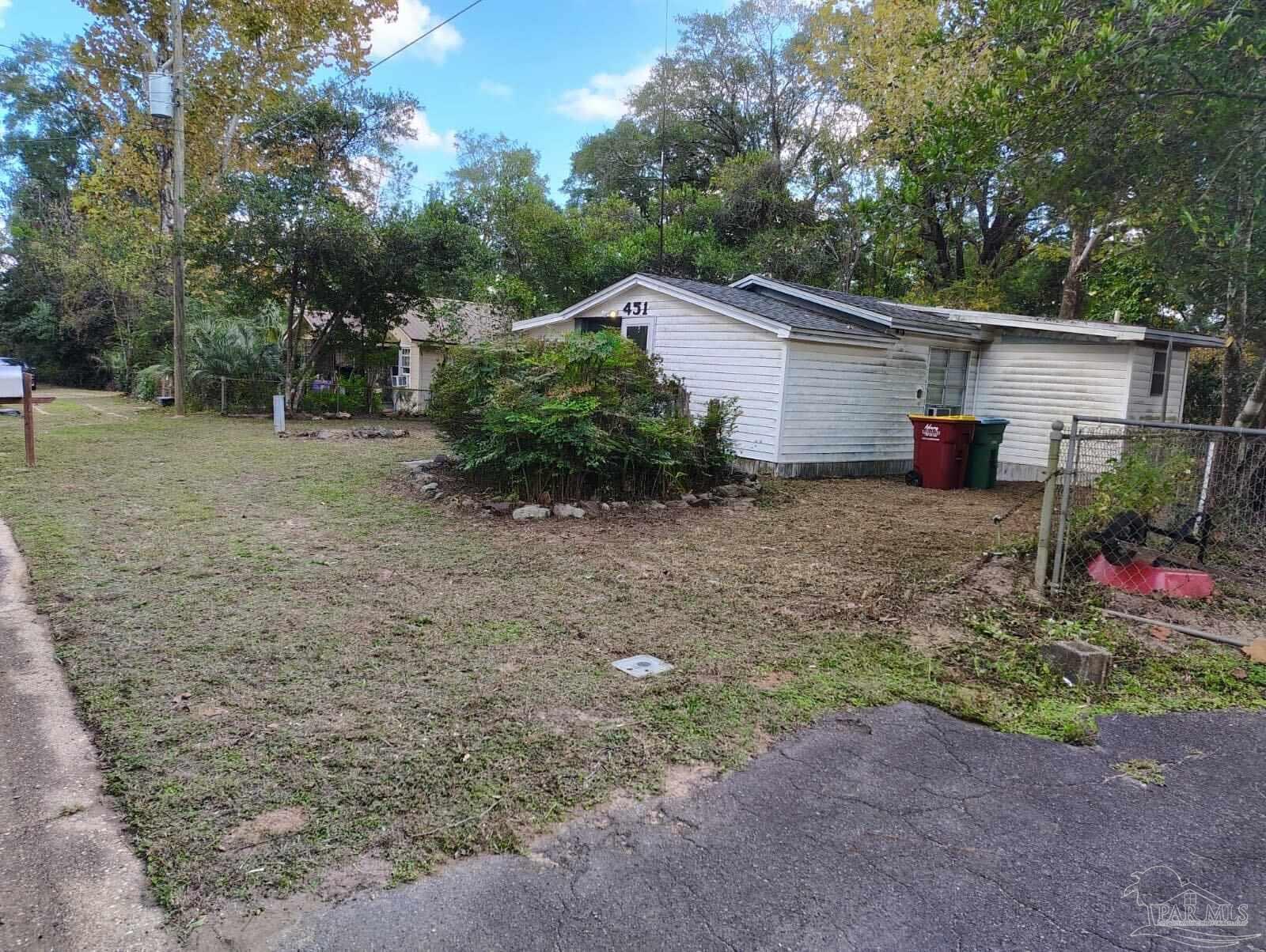 451 East Cane Avenue Crestview, FL 32539 - Photo 4 of 22 a view of a backyard with potted plants and large trees