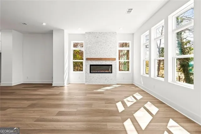 a view of an empty room with window and fire place